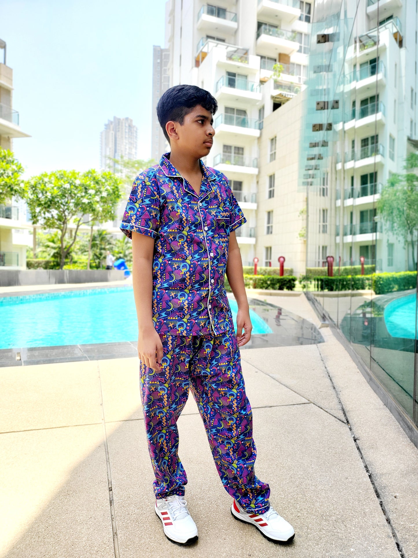 Unisex nightsuit in blue with bold geometric print in yellow and pink, ideal for kids who love bright and colorful designs