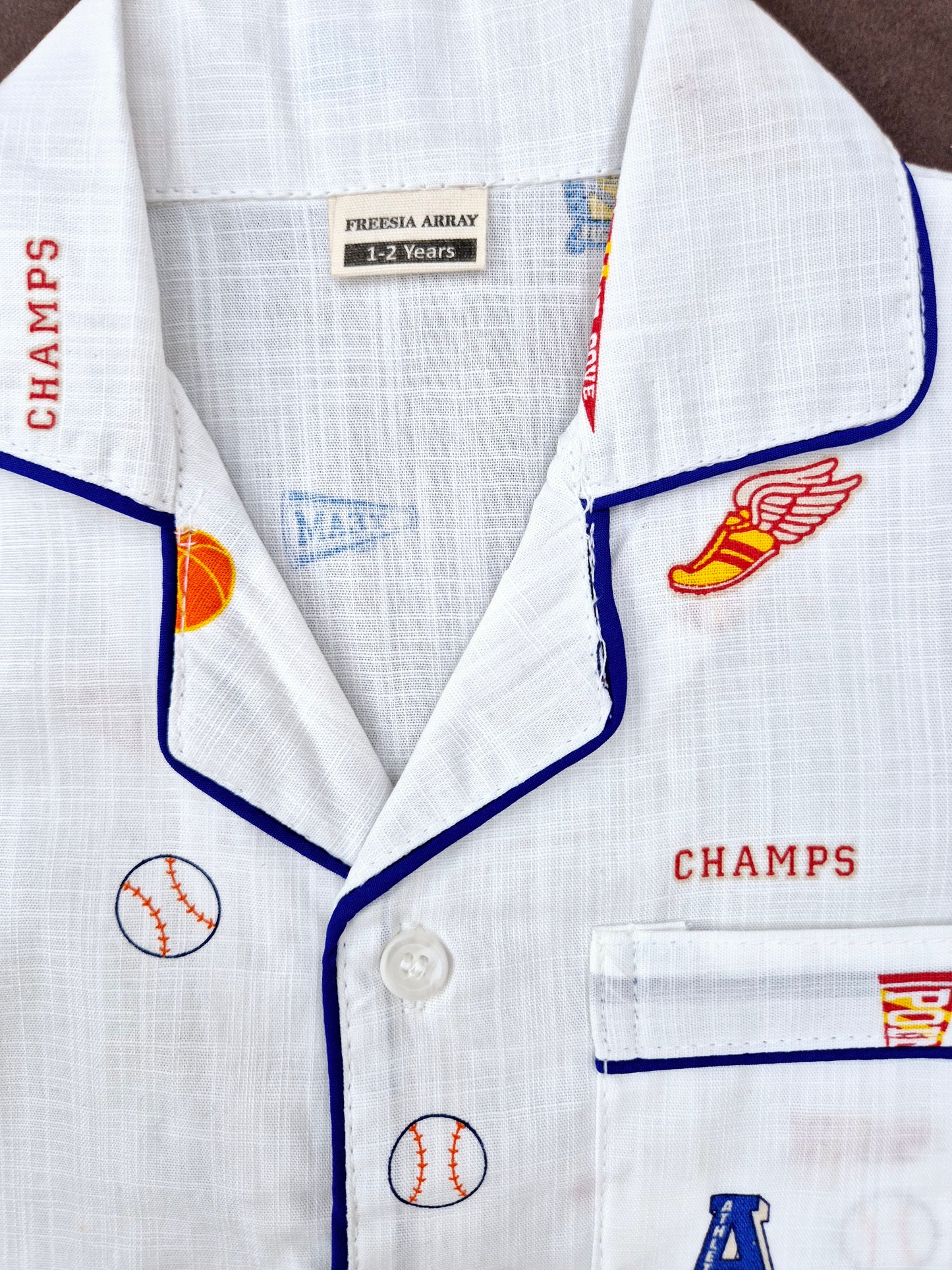 Boys and girls white night suit featuring rugby elements and 'CHAMP' slogan, ideal for playful bedtime.