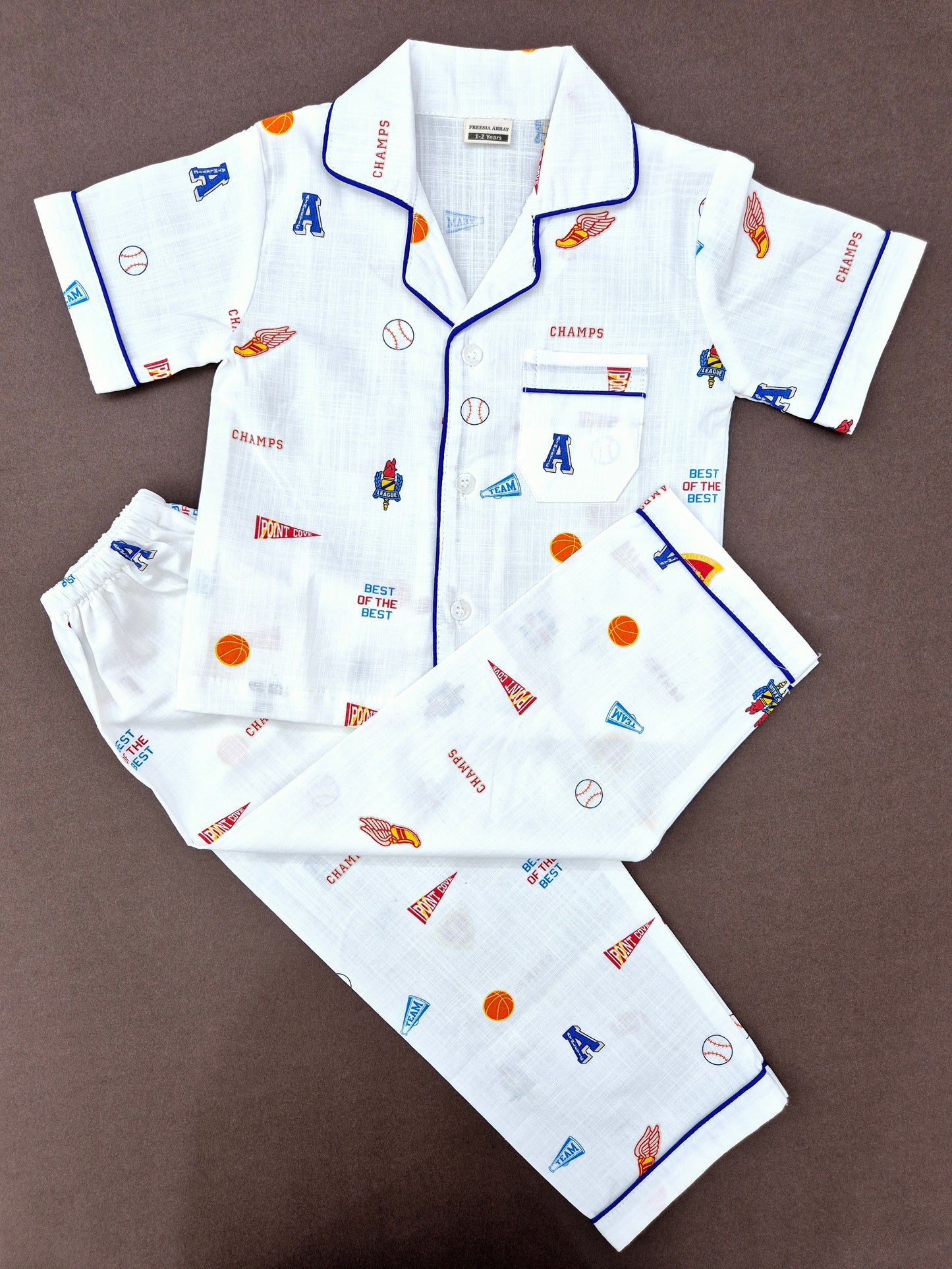 White unisex kids' nightwear set featuring a rugby-themed graphic and 'CHAMP' print, designed for comfort and style