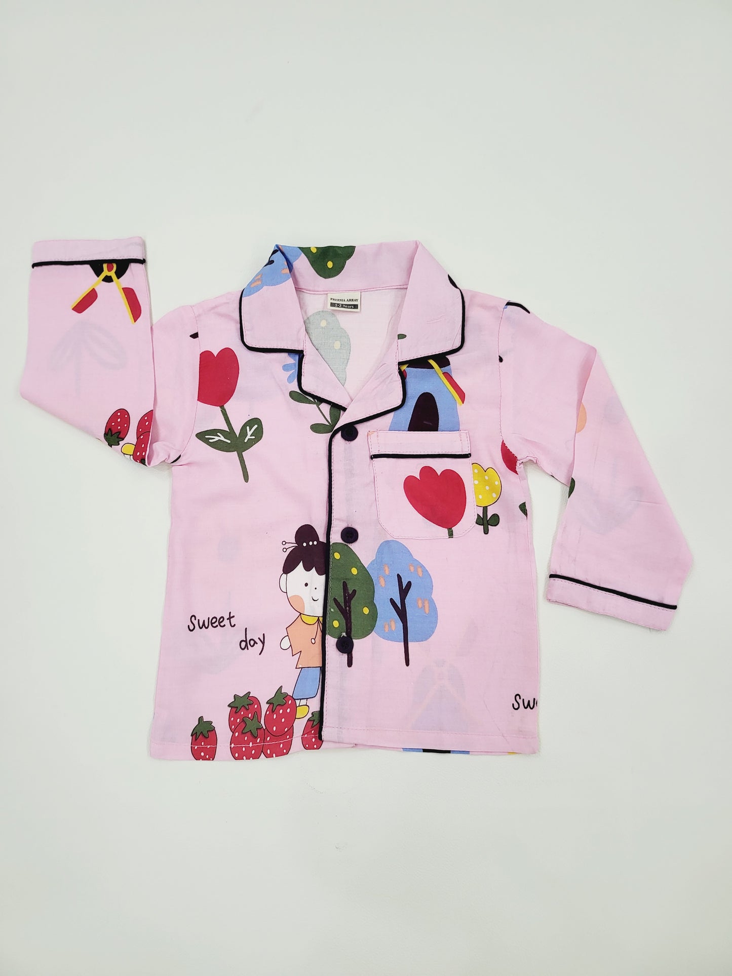 Flat lay of pink nightsuit with doll print, showcasing the vibrant colors and cute doll characters, ideal for kids' sleepwea