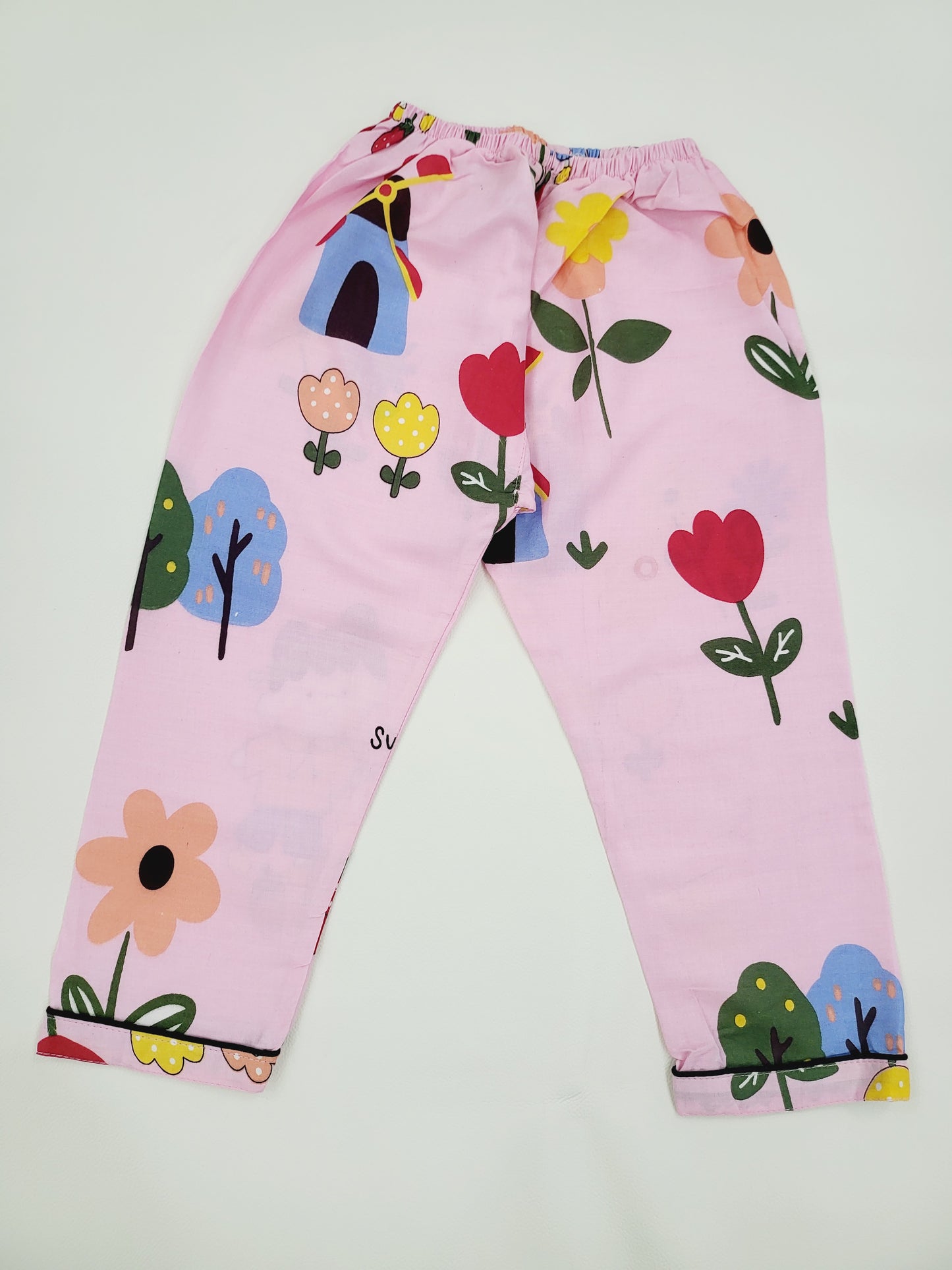 Pink nightsuit with doll print, displayed in a flat lay, showcasing the soft and cozy fabric, and the adorable doll characters, ideal for kids' bedtime