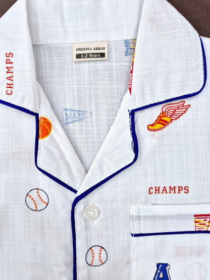 Boys and girls white night suit featuring rugby elements and 'CHAMP' slogan, ideal for playful bedtime.